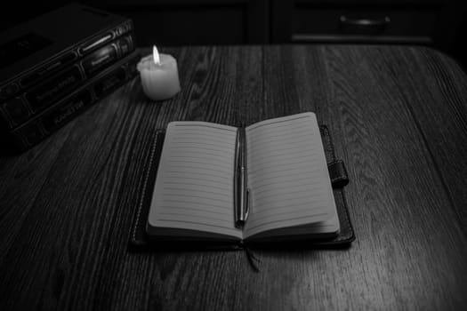 Black and White photo - Notepad with pen on a wooden table. Business, finance and creativity. Workplace. High quality photo