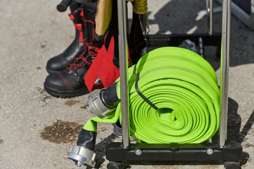 A neatly coiled fire hose lies on the ground, prepared and ready for immediate use in firefighting operations