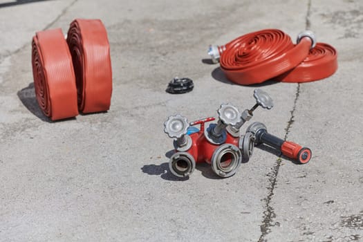 A neatly coiled fire hose lies on the ground, prepared and ready for immediate use in firefighting operations