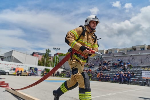 In a dynamic display of synchronized teamwork, firefighters hustle to carry, connect, and deploy firefighting hoses with precision, showcasing their intensive training and readiness for challenging and high-risk situations ahead.