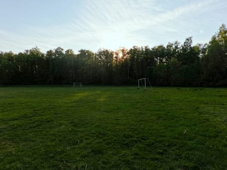 A football field in the middle of the forest. White football gates . High quality photo