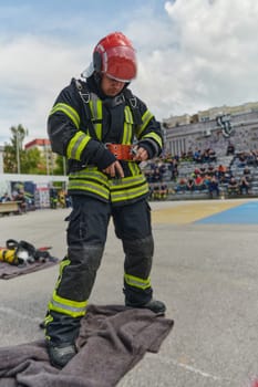 A firefighter dons the essential components of their professional gear, embodying resilience, commitment, and readiness as they gear up for a hazardous firefighting mission, a testament to their unwavering dedication to protecting and saving lives.