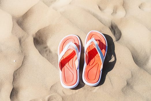 A pair of flip-flops on the sand of a beach.