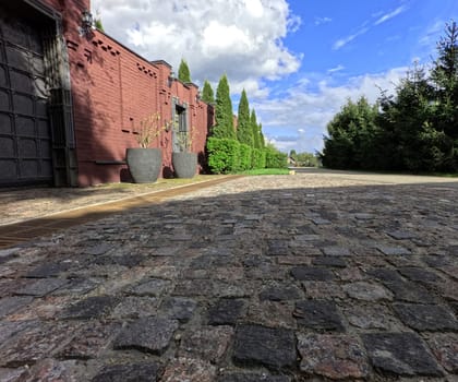 A paved stone road along a beautiful red architectural building. High quality photo