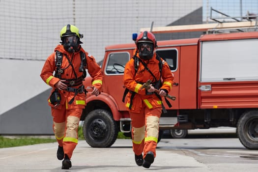 A team of firefighters, dressed in professional gear, undergoes training to learn how to use various firefighting tools and prepare for firefighting tasks.