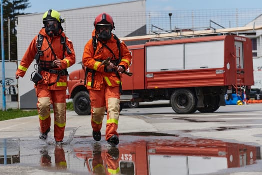 A team of firefighters, dressed in professional gear, undergoes training to learn how to use various firefighting tools and prepare for firefighting tasks.