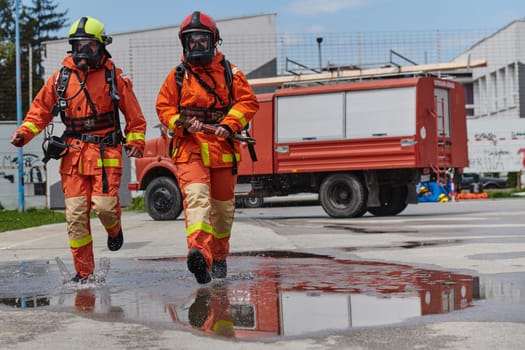 A team of firefighters, dressed in professional gear, undergoes training to learn how to use various firefighting tools and prepare for firefighting tasks.