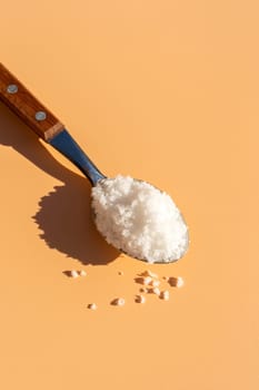 Top View Mockup Kosher Mineral Unrefined Sea Salt in Table Spoon, Natural Grain Crystals, Copy Space for Text. Beach Yellow Background. Baja Salt. Vertical Plane, Template. High quality photo