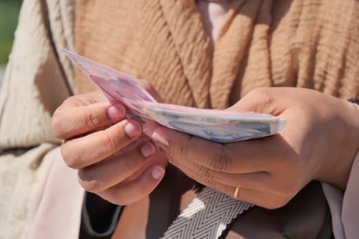 women hand counting cash closeup .