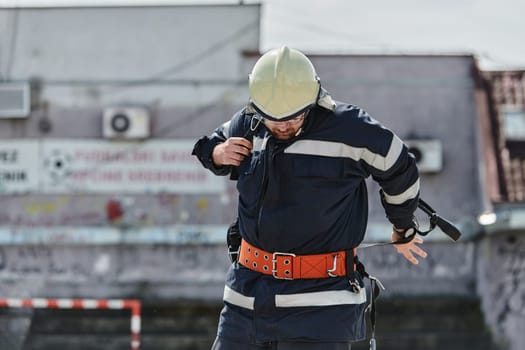 A firefighter dons the essential components of their professional gear, embodying resilience, commitment, and readiness as they gear up for a hazardous firefighting mission, a testament to their unwavering dedication to protecting and saving lives.