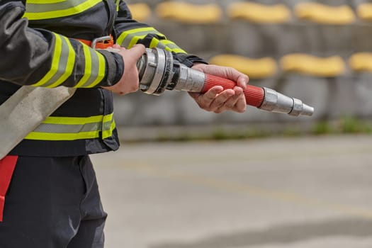 Professional firefighter undergoes training on the proper usage of a water hose for firefighting operations