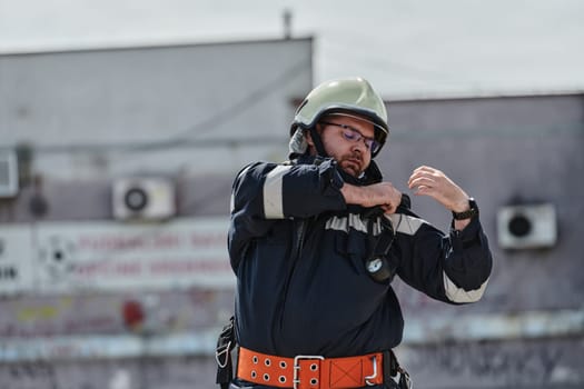 A firefighter dons the essential components of their professional gear, embodying resilience, commitment, and readiness as they gear up for a hazardous firefighting mission, a testament to their unwavering dedication to protecting and saving lives.