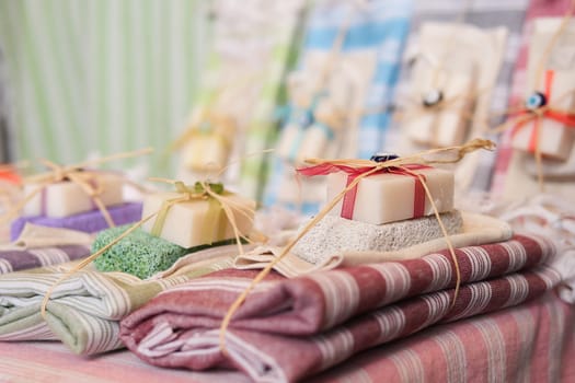 Beautifully arranged handmade soap bars and folded towels, wrapped with ribbon for a charming display.