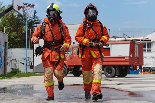 A team of firefighters, dressed in professional gear, undergoes training to learn how to use various firefighting tools and prepare for firefighting tasks.