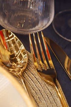 This is a detailed closeup of elegant, shiny silver spoons reflecting light patterns on a wooden surface