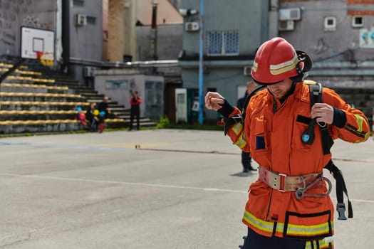 A professional firefighter dons his protective gear, preparing to respond to an emergency call.