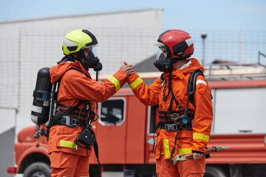 A unified team of firefighters, adorned in their uniforms, engages in a heartfelt celebration marked by triumphant salutes and cheers, embodying the joy and gratitude following the successful completion of a challenging firefighting mission.