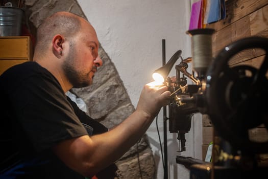 shoemaker preparing the sewing machine to carry out his work