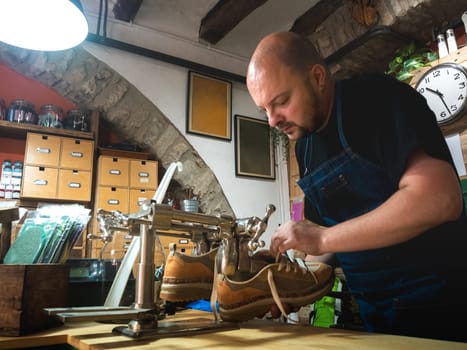 shoemaker putting lasts on shoes to give them shape