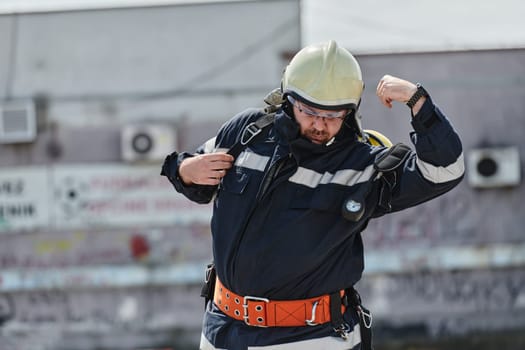 A firefighter dons the essential components of their professional gear, embodying resilience, commitment, and readiness as they gear up for a hazardous firefighting mission, a testament to their unwavering dedication to protecting and saving lives.