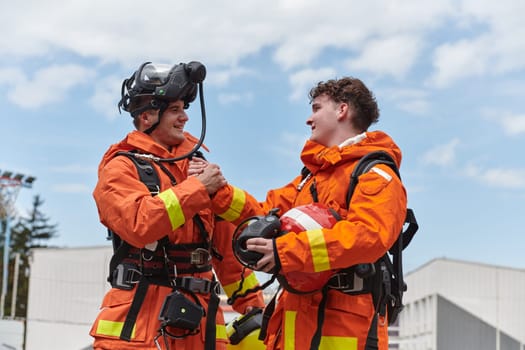 A unified team of firefighters, adorned in their uniforms, engages in a heartfelt celebration marked by triumphant salutes and cheers, embodying the joy and gratitude following the successful completion of a challenging firefighting mission.