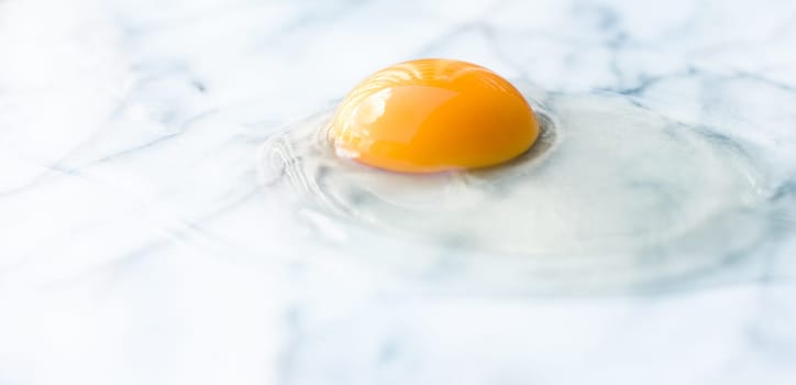 egg yolk on marble - recipe ingredients and homemade cooking styled concept