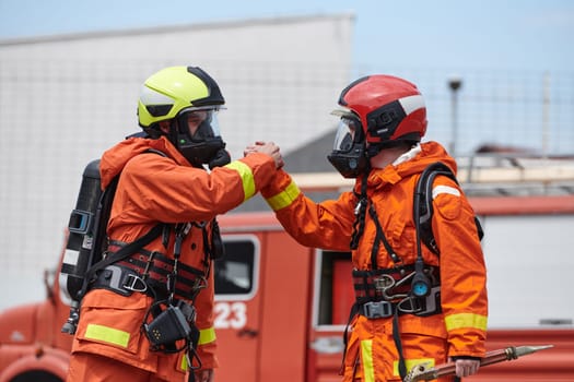 A unified team of firefighters, adorned in their uniforms, engages in a heartfelt celebration marked by triumphant salutes and cheers, embodying the joy and gratitude following the successful completion of a challenging firefighting mission.