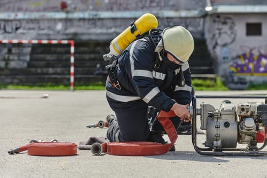 A firefighter dons the essential components of their professional gear, embodying resilience, commitment, and readiness as they gear up for a hazardous firefighting mission, a testament to their unwavering dedication to protecting and saving lives.