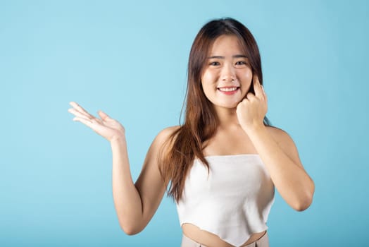 Skin care and Beauty concept. Portrait happy woman with natural makeup and healthy face studio shot isolated on blue background, Asian young female with beauty face touching healthy facial skin