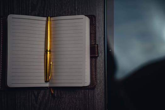 Workplace. Notebook with pen and tablet on a wooden table. Strict style. High quality photo