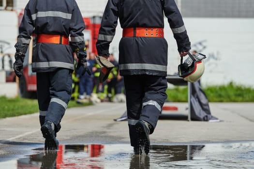 A team of confident and accomplished firefighters strides purposefully in their uniforms, exuding pride and satisfaction after successfully completing a challenging firefighting mission.