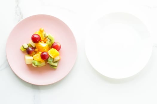 juicy fruit salad for breakfast on marble, flatlay - dieting and healthy lifestyle styled concept