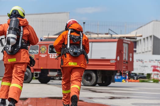 A team of firefighters, dressed in professional gear, undergoes training to learn how to use various firefighting tools and prepare for firefighting tasks.