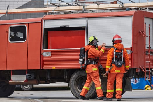 A team of firefighters, dressed in professional gear, undergoes training to learn how to use various firefighting tools and prepare for firefighting tasks.