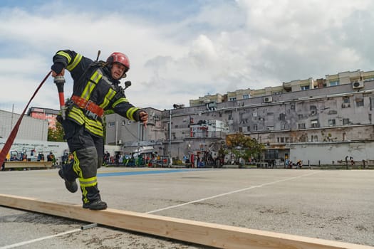 In a dynamic display of synchronized teamwork, firefighters hustle to carry, connect, and deploy firefighting hoses with precision, showcasing their intensive training and readiness for challenging and high-risk situations ahead.