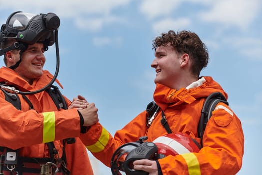 A unified team of firefighters, adorned in their uniforms, engages in a heartfelt celebration marked by triumphant salutes and cheers, embodying the joy and gratitude following the successful completion of a challenging firefighting mission.