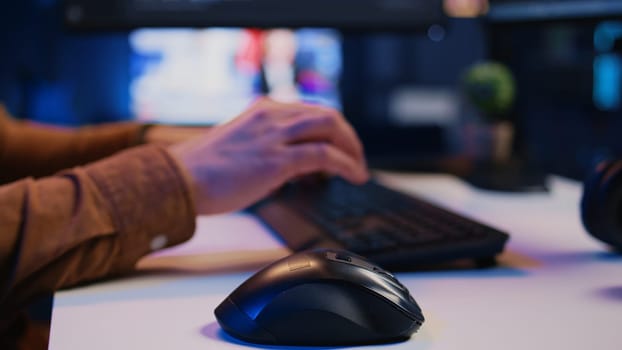 Focus on computer peripherals used by programmer to write lines of code on PC screen. Close up shot of keyboard and mouse used by developer working on fixing database errors, camera B