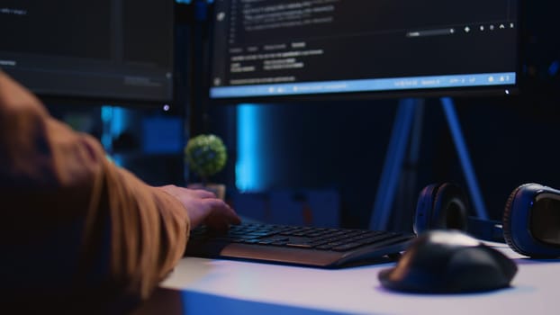 Focus on computer peripheral used by IT admin to type lines of code on desktop PC in apartment. Close up shot of keyboard used by software engineer programming at home, camera B