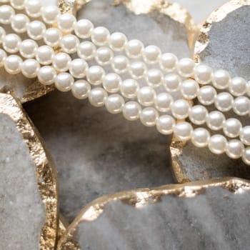 Pearl necklace on golden marble, ethical jewellery - luxury background, jewelry as a gift concept. Pearls are girl's best friends