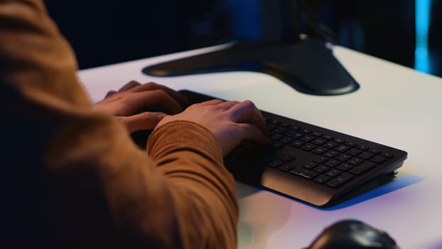 Computer scientist listening music while writing lines of code during remote job shift in home office. IT specialist enjoying audio podcast, coding on desktop PC, camera A extreme close up