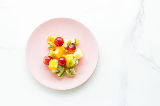 juicy fruit salad for breakfast on marble, flatlay - dieting and healthy lifestyle styled concept