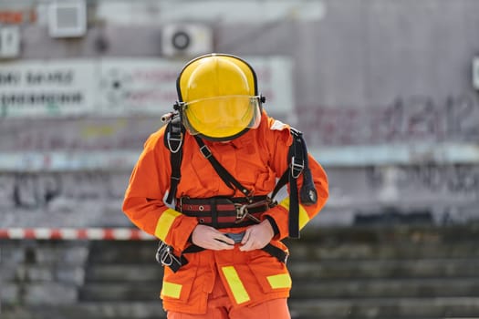 A firefighter dons the essential components of their professional gear, embodying resilience, commitment, and readiness as they gear up for a hazardous firefighting mission, a testament to their unwavering dedication to protecting and saving lives.