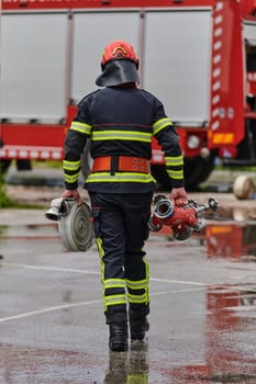 In a dynamic display of synchronized teamwork, firefighters hustle to carry, connect, and deploy firefighting hoses with precision, showcasing their intensive training and readiness for challenging and high-risk situations ahead.