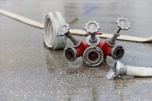 A neatly coiled fire hose lies on the ground, prepared and ready for immediate use in firefighting operations