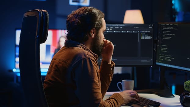 Stressed engineer feeling pressed by deadline, thinking how to finish developing code on PC. IT specialist brainstorming ways of solving database errors, working hard, drinking coffee, camera A