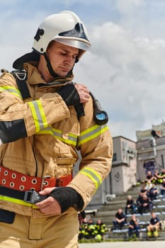 A firefighter dons the essential components of their professional gear, embodying resilience, commitment, and readiness as they gear up for a hazardous firefighting mission, a testament to their unwavering dedication to protecting and saving lives.