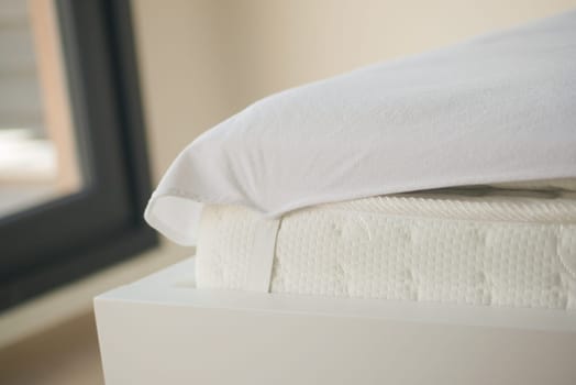 A white mattress with a knitted design and neutral tones offers a comfortable experience in a closeup view