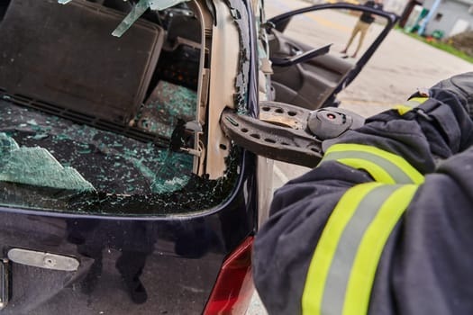 A dedicated team of professional firefighters employs specialized tools to cut and break through vehicle wreckage, showcasing their skilled collaboration and swift response in rescuing individuals involved in a car accident.