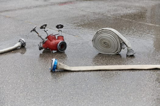 A neatly coiled fire hose lies on the ground, prepared and ready for immediate use in firefighting operations