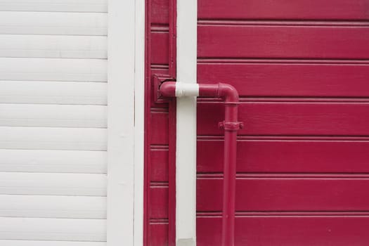 red wall with pipe, displaying modern urban design with vibrant colors,